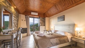Une chambre avec un grand lit, un bureau avec une télévision, une fenêtre avec des rideaux et une vue sur l’extérieur.