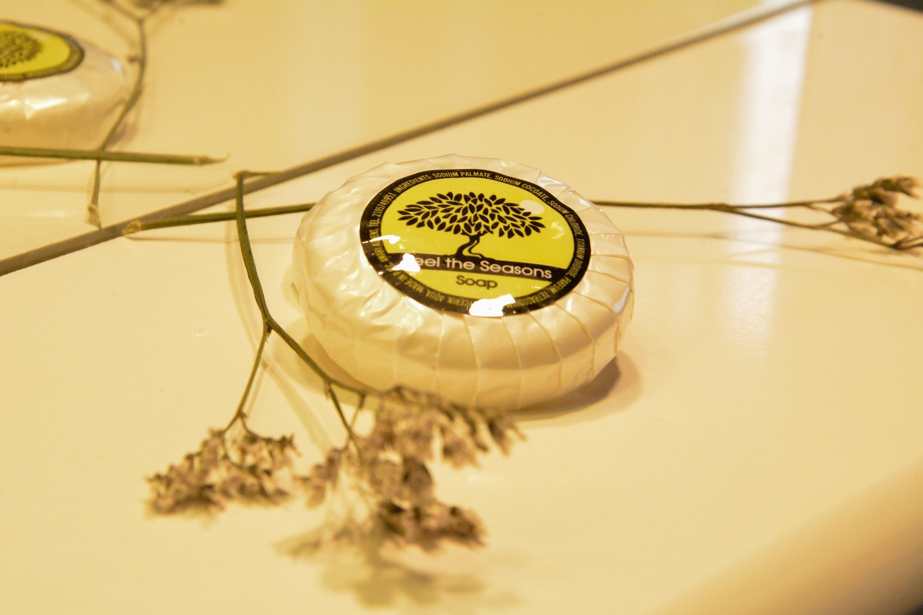 Una pastilla de jabón con etiqueta de árbol sobre una superficie blanca.