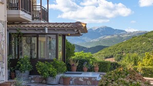 Une maison dotée d’un balcon donnant sur un paysage montagneux.