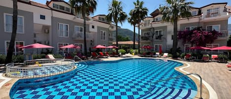 Piscine extérieure, parasols de plage, chaises longues