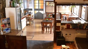 Amplia sala de estar con piso de madera, una mesa de comedor y una cocina al fondo.