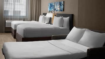 Quarto de hotel com duas camas, uma janela grande com cortinas, uma obra de arte na parede e um abajur.