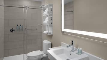 A modern bathroom with a toilet, shower, and sink.