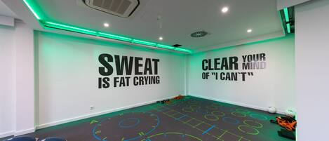 A gym with motivational wall art and a floor marked for exercise.