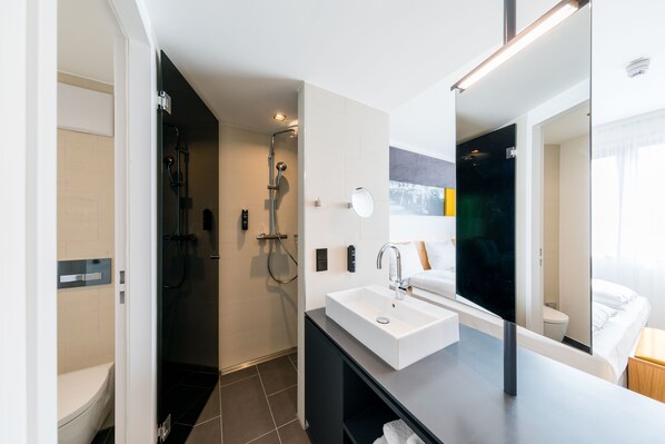 Un baño moderno con ducha, inodoro y lavabo.