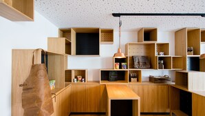 Une cuisine moderne avec des meubles en bois, un tablier suspendu et un luminaire suspendu.