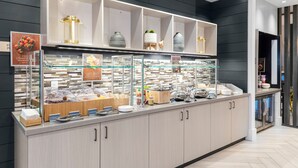 A buffet area with various food stations, including a section for fruits and a display of decorative vases. - SpringHill Suites by Marriott Great Falls (Great Falls)