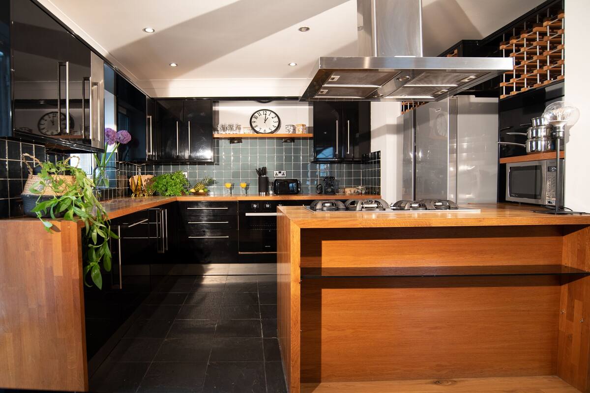 Design appartement | Privékeuken | Een koelkast met diepvriezer, een microgolfoven, een oven, een kookplaat