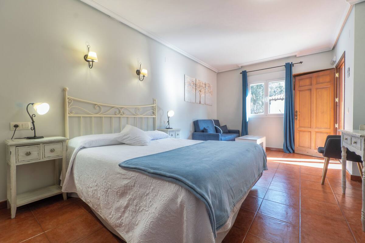 Ein Schlafzimmer mit Bett, Nachttischen, Schreibtisch und Stuhl.