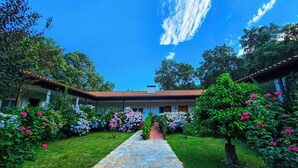 A courtyard with a stone pathway leading to a building with a tiled roof. - Hotel Rural El Retiro de San Pedro (Arenas de San Pedro)