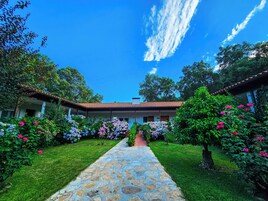 Un patio con un sendero de piedra que conduce a un edificio con tejado de baldosas.