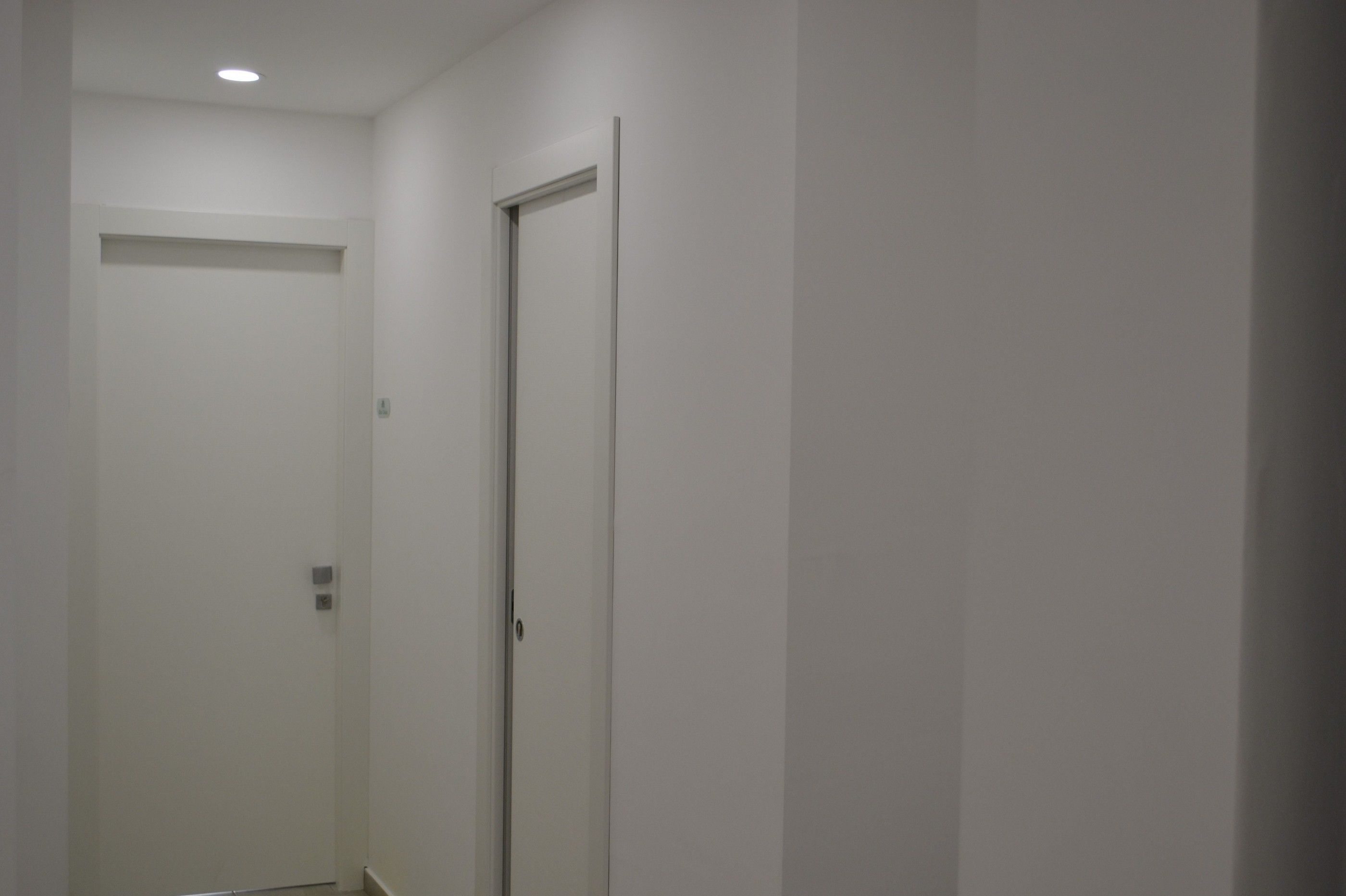 A narrow hallway with a closed door at the end.