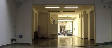 A long, narrow hallway with a car parked at the end.