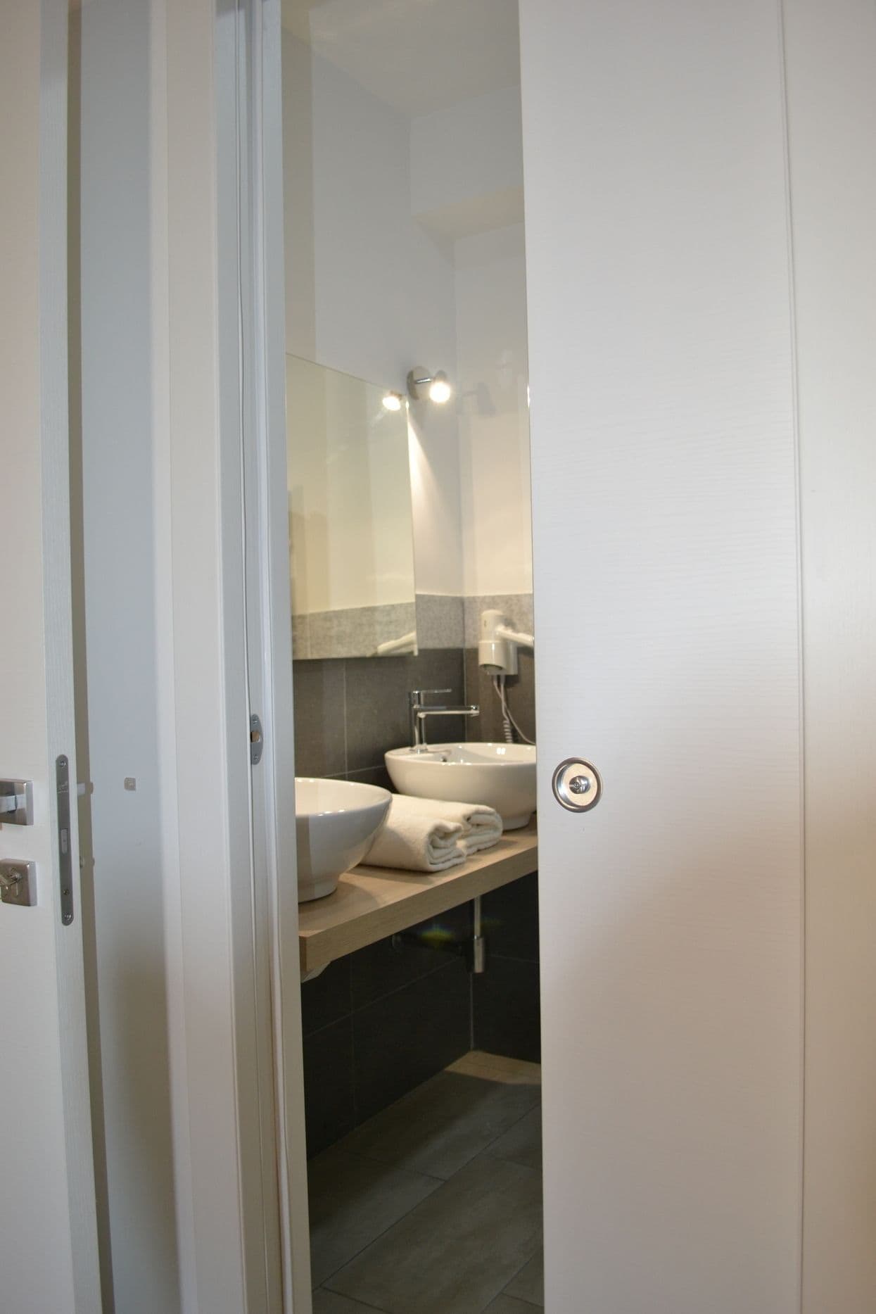 A bathroom with a white sink, a mirror, and a towel rack.
