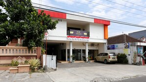 A two-story building with a Galaxy sign, a parked car, and a red and white awning. - RedDoorz near Adisucipto Airport 3 (Kalasan)