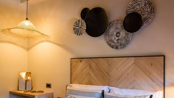 Un dormitorio moderno con un cabecero de madera en espiga, una mesita de noche con espejo y decoración en la pared.