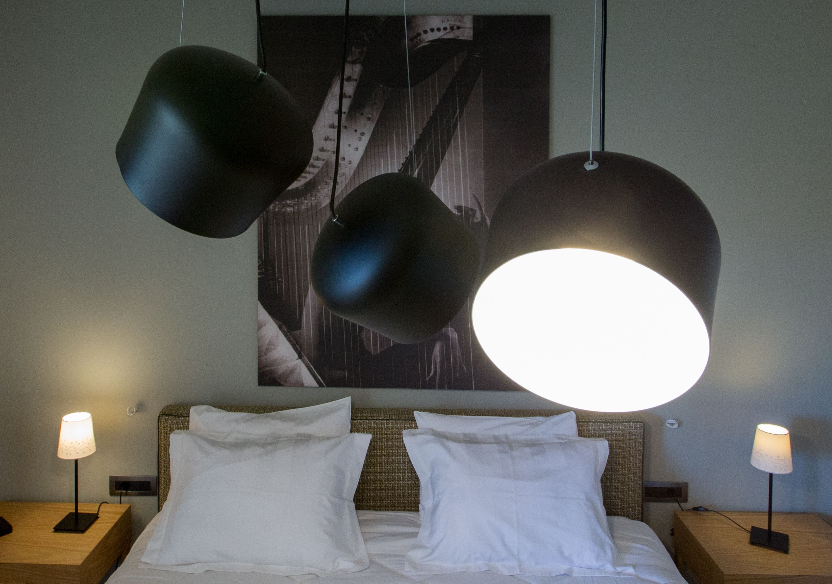 A neatly made bed with white linens and two bedside lamps on wooden nightstands.
