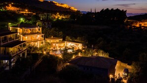 A multi-story building with a swimming pool, surrounded by trees and hills. - Anthemion Suites & Villas (Nafplio)