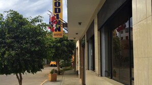A hotel exterior with a sign reading "HOSTAL ROODN" and a tree-lined sidewalk. - Hostal Rodinn (Nazca)