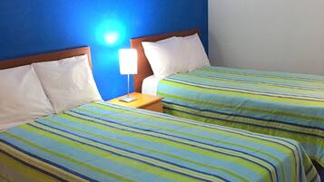 A hotel room with two beds, a nightstand, a lamp, and a painting on the wall.