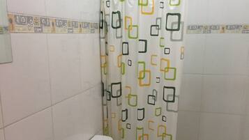 A bathroom with a toilet, sink, and shower curtain.