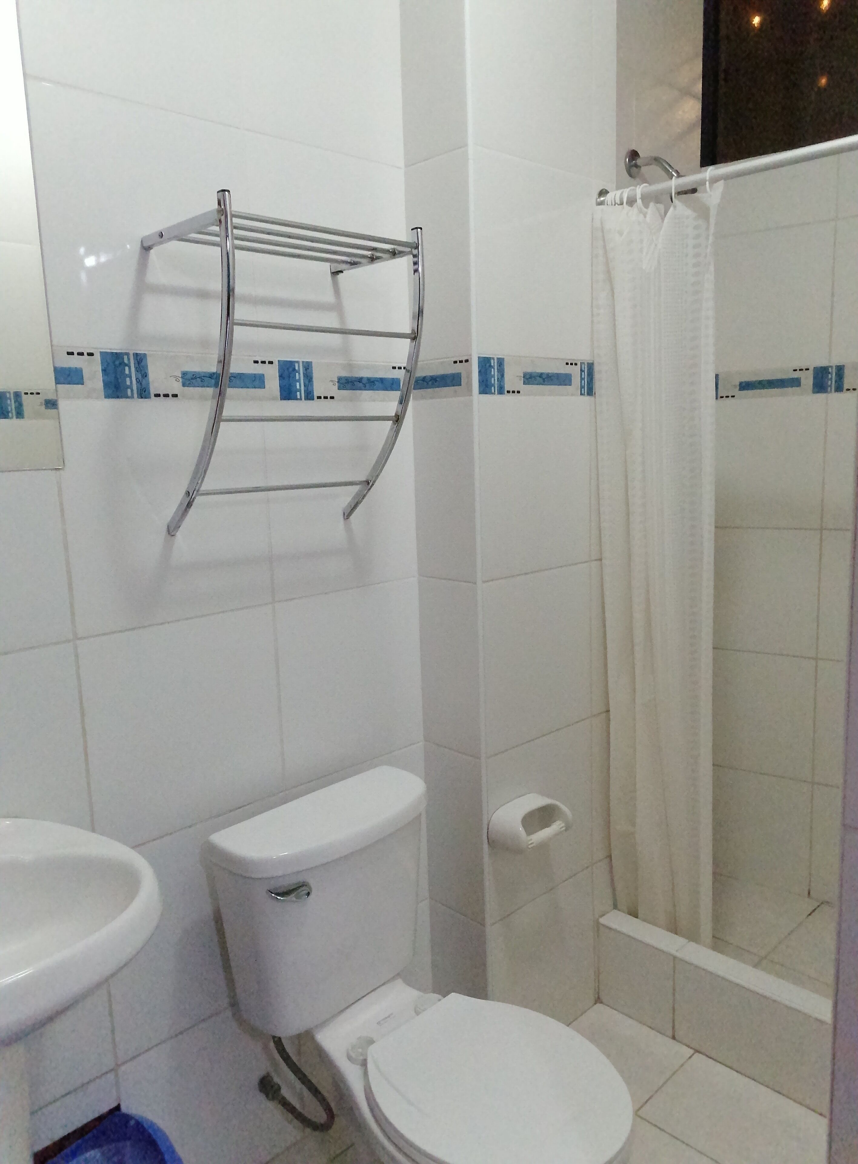 A bathroom with a toilet, sink, and shower.