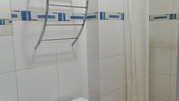 A bathroom with a toilet, sink, and shower.