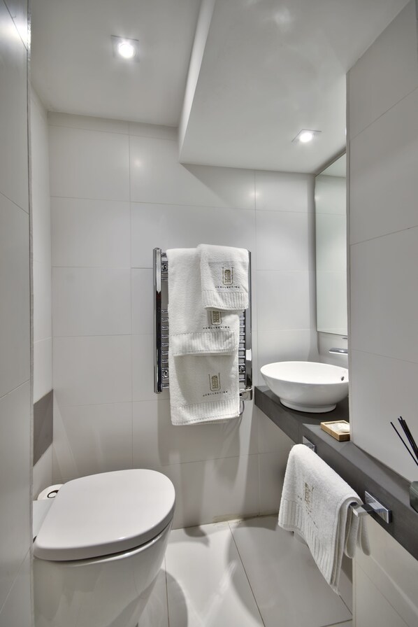 Ein modernes Badezimmer mit Toilette, Waschbecken und Handtuchhalter.