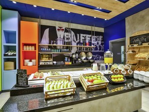A café counter with a variety of fruits, a coffee machine, and a chalkboard menu. - ibis budget Sorocaba (Sorocaba)