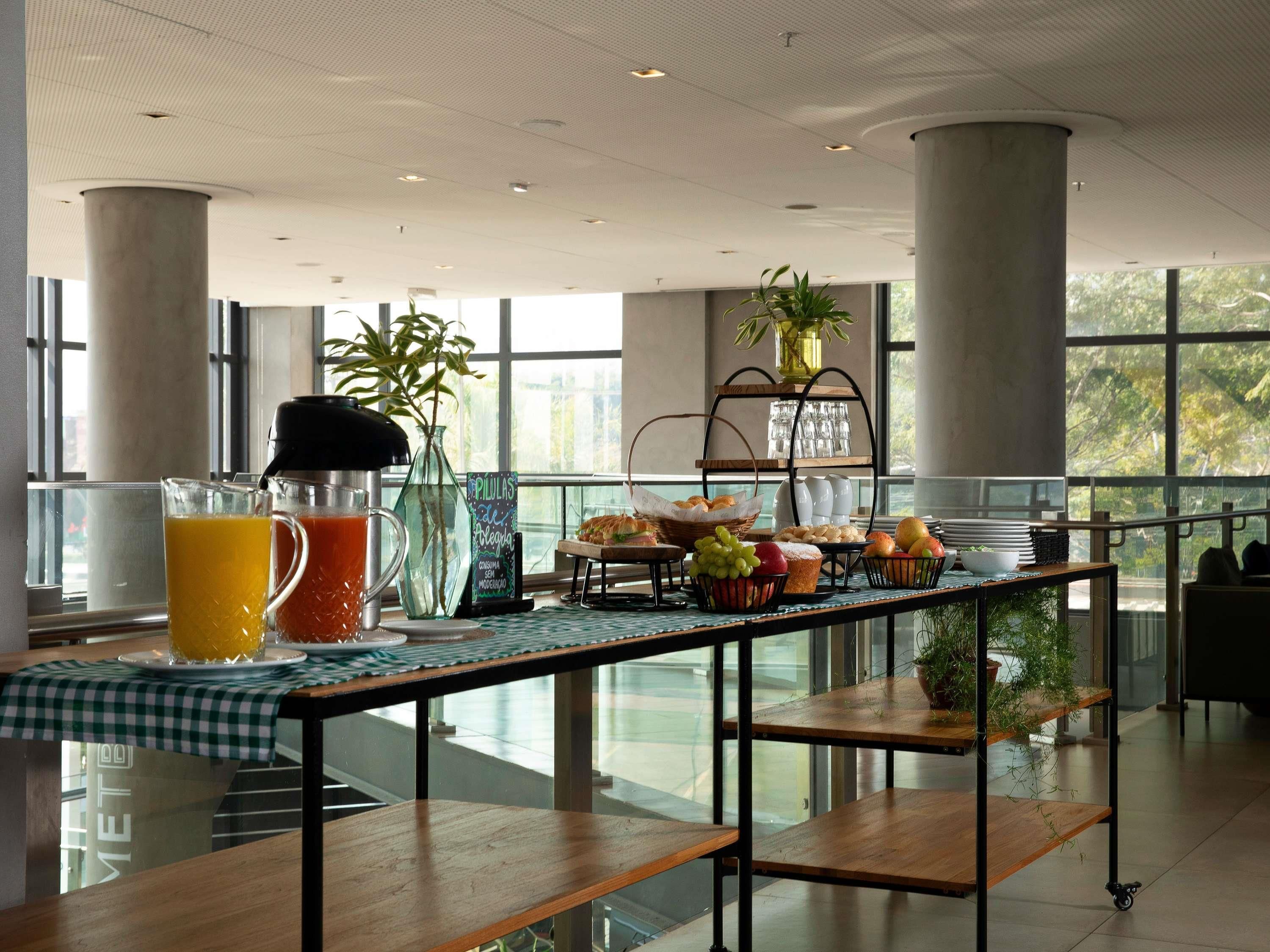 Ein Frühstücksbuffet mit verschiedenen Speisen, einer Kaffeemaschine und einer Pflanze in einem Fenster.