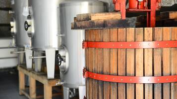 Industrial brewing tanks and a wooden barrel with metal bands.