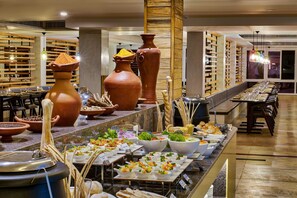 Una mesa de buffet con diversos alimentos y cerámica tradicional.