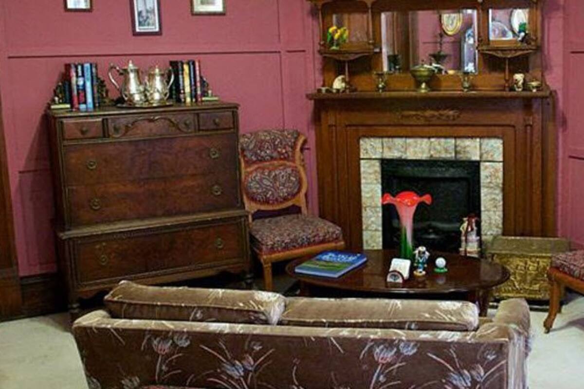 Un salón tradicional con chimenea, muebles de madera y una estantería.