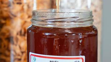 A jar of Miel de Narbonne honey being poured.