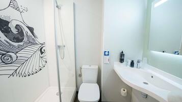 A modern bathroom with a shower, toilet, and sink.