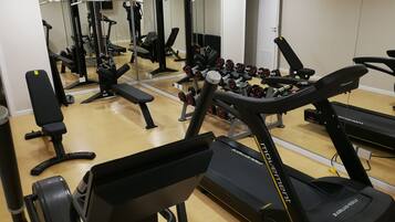 A gym with treadmills, dumbbells, and weight machines.