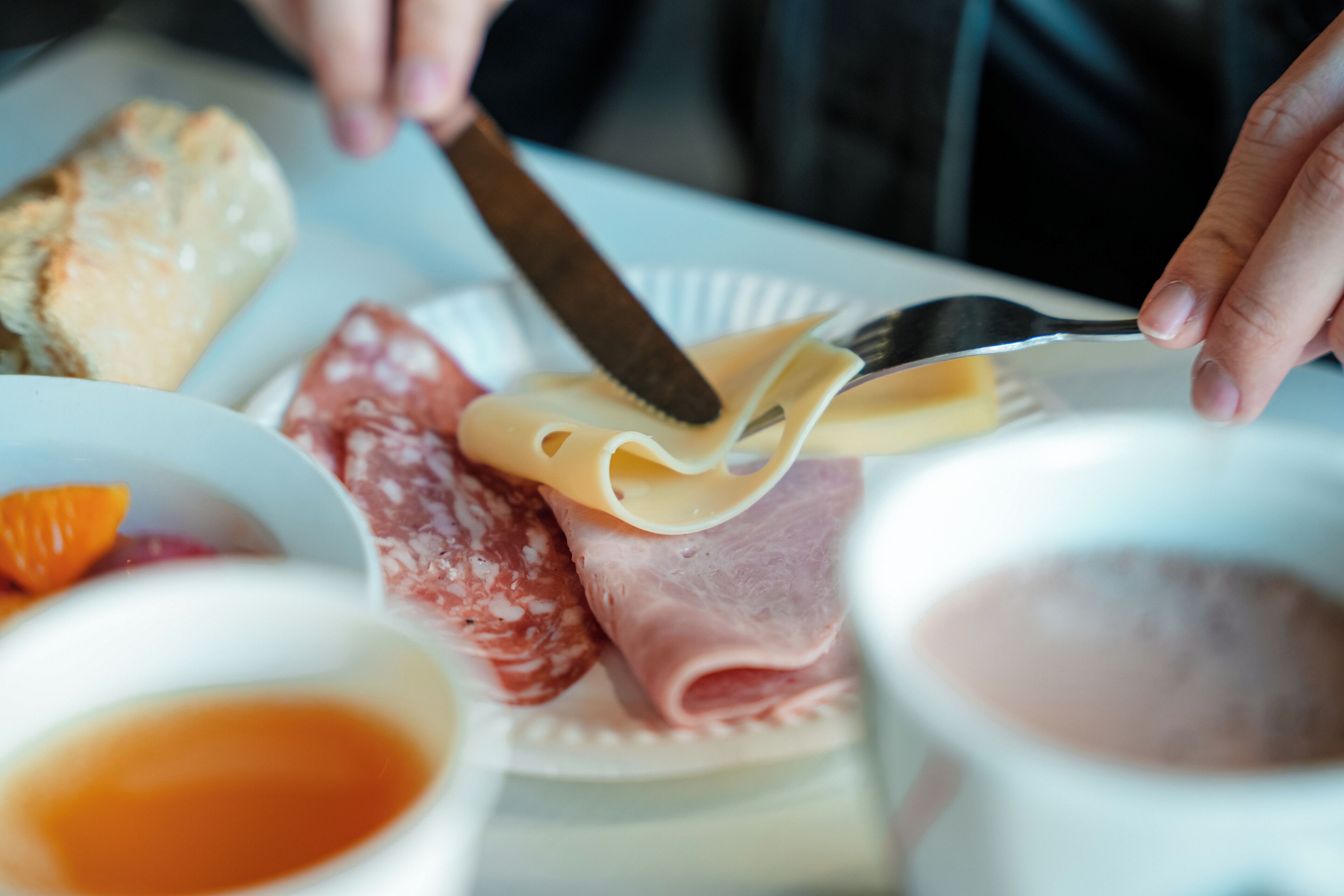 A plate with various food items including cheese, salami, and a pastry.