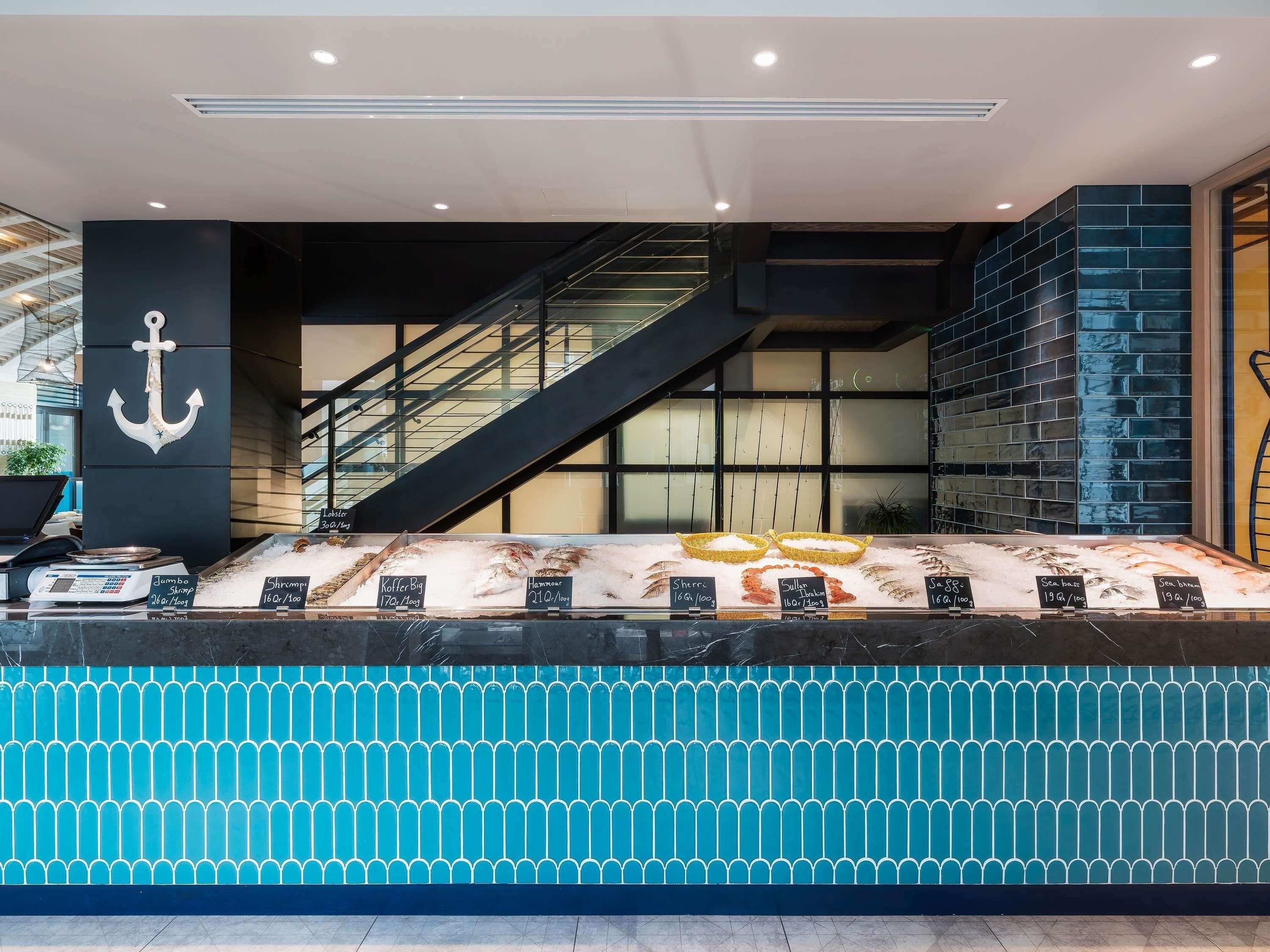 A seafood display counter with various seafood items and a staircase leading to an upper level.