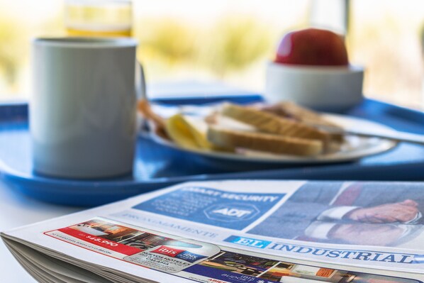 Un periódico con el titular "INDUSTRIAL" sobre una mesa con una bandeja.