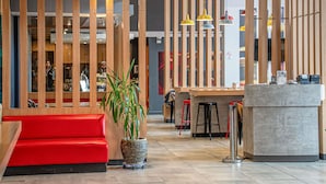 A modern interior with a red sofa, a reception desk, and a wooden partition. - ibis Iquique (Iquique)