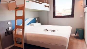 Un letto a castello con una scala, un comodino con un telecomando, una finestra con vista e un piccolo sgabello.