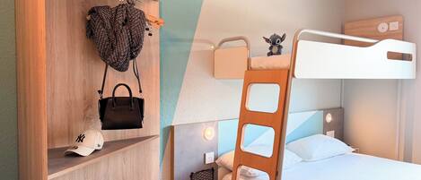 A bunk bed with a ladder, a wooden wardrobe with shelves, and a small nightstand with a lamp.