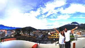 Une terrasse avec vue sur la ville et les montagnes.