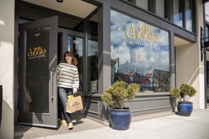 Una fachada con un amplio escaparate que muestra prendas de vestir y un cartel que dice "cheeks BOUTIQUE JEANS".