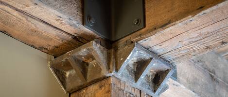 A wooden beam structure with metal brackets and a concrete base.