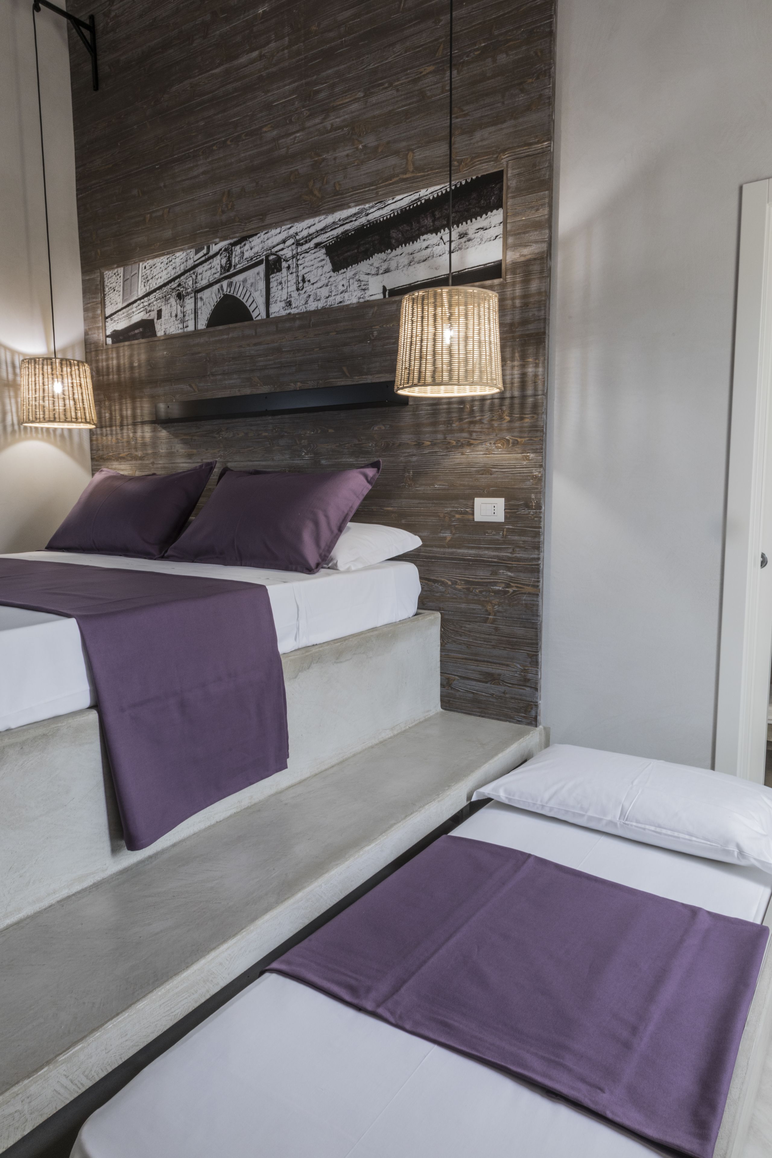 Ein modernes Schlafzimmer mit einem Bett, einer Bank und einem Wandregal.