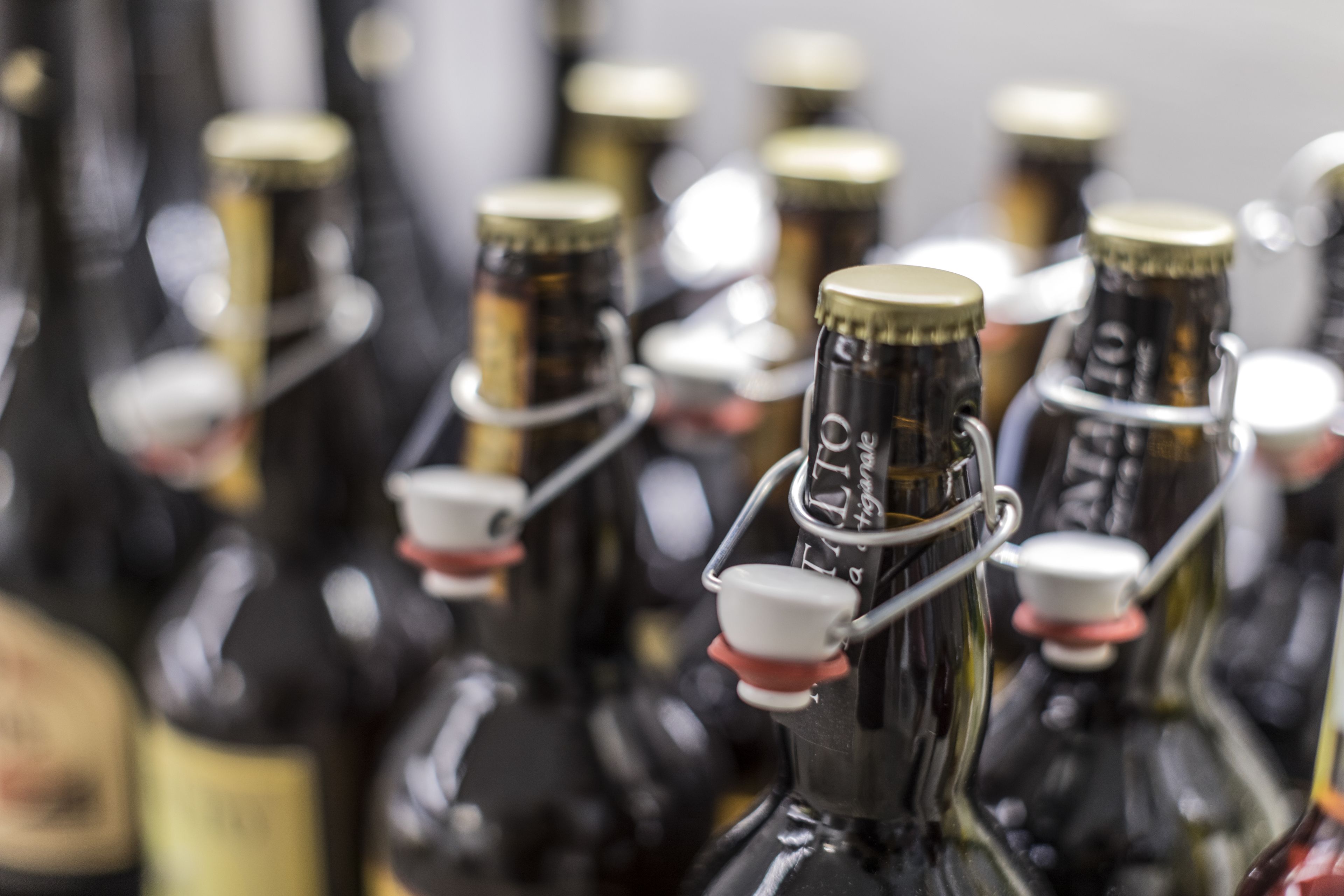 A row of dark glass bottles with metal caps, some with labels visible.