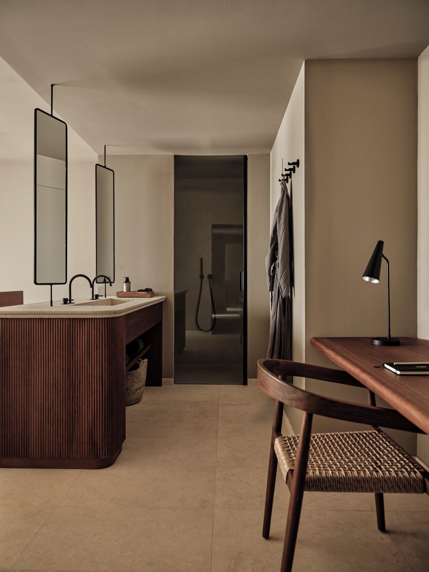 Un baño moderno con un tocador de madera, un espejo grande y zona de ducha.