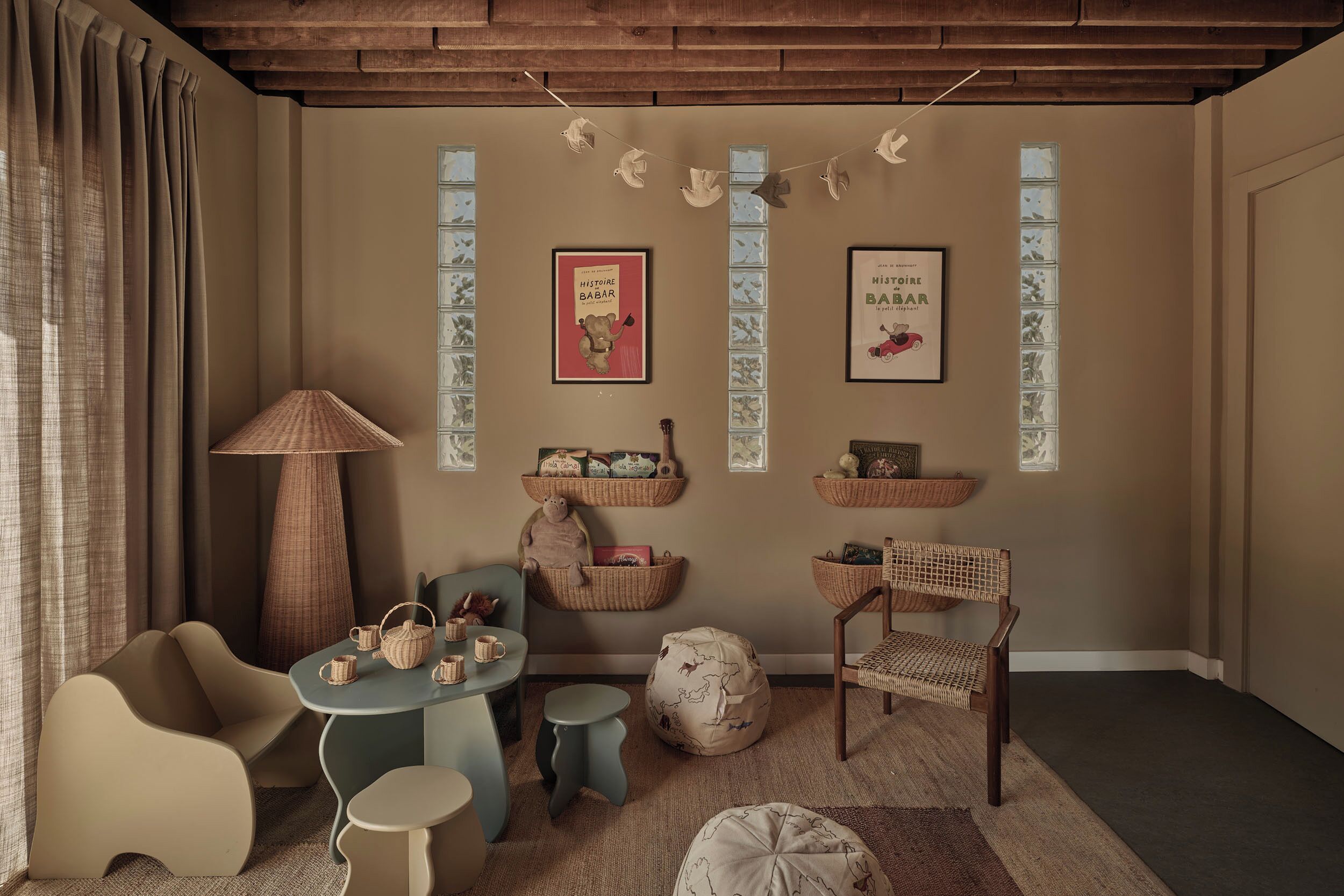 Een gezellige kamer met een houten plafond, een tafel met stoelen, een lamp en decoratieve objecten aan de muren.
