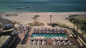 Een seizoensgebonden buitenzwembad, parasols voor strand/zwembad